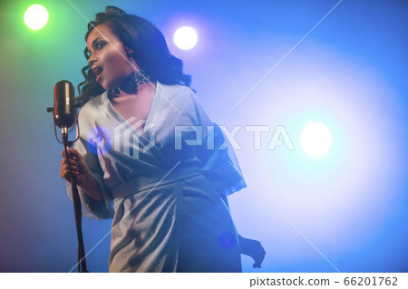 A jazz singer performs on stage. Afro. 66201762