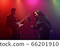 A jazz singer and guitarist perform on stage. 66201910