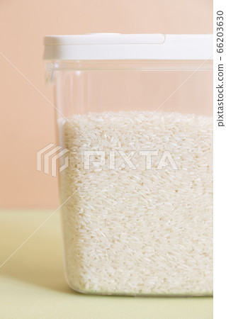 Plastic transparent container with rice on a green background. Plastic transparent container with rice on a green background. 66203630