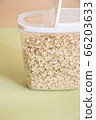 Plastic transparent container with oatmeal on a green background. 66203633