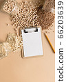 Cereals in glass jars on the table next to a Notepad and pencil. Space for text, white sheet of paper. 66203639
