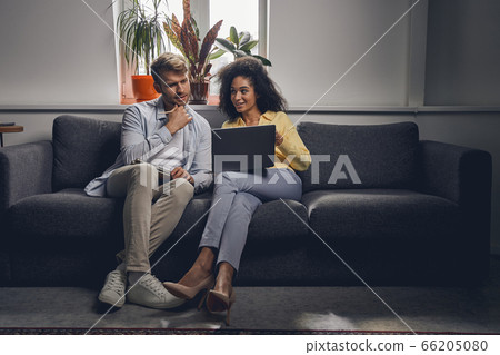 Smiling lady staring at her male coworker 66205080