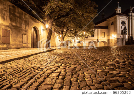 Narrow cobbled street in old medieval town with illuminated houses by vintage street lamps, Novy svet, Prague, Czech Republic. Night shot Narrow cobbled street in old medieval town with illuminated houses by vintage street lamps, Novy svet, Prague, Czech Republic. Night shot 66205293