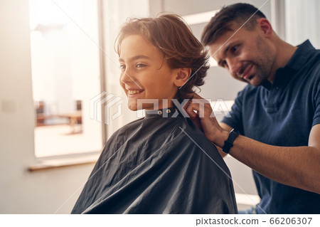 Handsome Caucasian hairdresser staying with little child 66206307