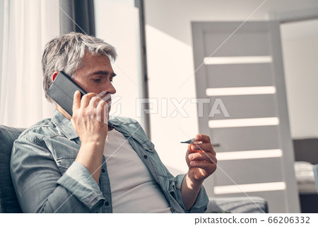 Grey haired man calling from living room Grey haired man calling from living room 66206332