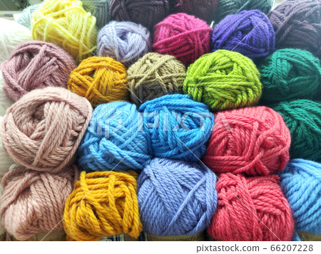 Many multi-colored wool skeins next to each other Many multi-colored wool skeins next to each other 66207228