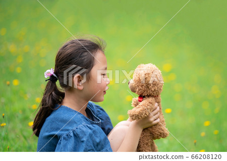 Girl sitting with a teddy bear 66208120