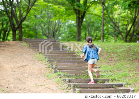 Girl climbing stairs in park 66208317