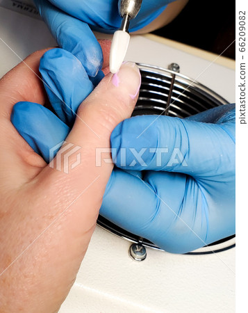 processing of nails with hardware manicure in a beauty salon 66209082