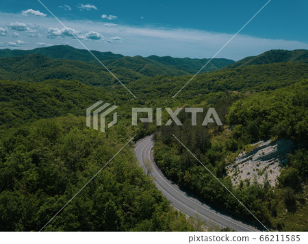 Mountain winding zig zag road. Top aerial view: cars driving on road from above. 66211585