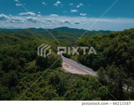 Mountain winding zig zag road. Top aerial view: cars driving on road from above. 66211587