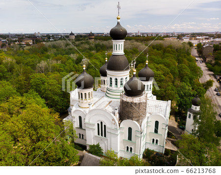 White orthodox church among green trees with dome under reconstruction aerial. St. John the Forerunner 66213768