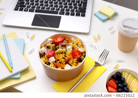 Food in taking away boxes on white table with laptop Food in taking away boxes on white table with laptop 66215022