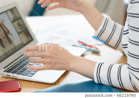 Hands of a woman holding a remote meeting on a computer 66219760