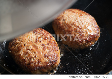 在煎鍋中烤漢堡包打開鍋蓋 在煎鍋中烤漢堡包打開鍋蓋 66219770