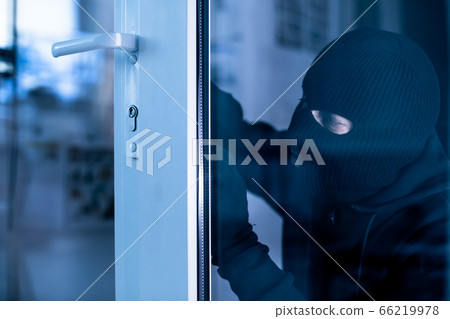 Robber in black balaclava cracking door with metal picklock Robber in black balaclava cracking door with metal picklock 66219978
