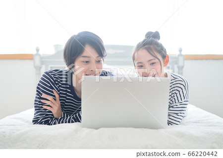 看在床上的年輕夫婦個人計算機 看在床上的年輕夫婦個人計算機 66220442