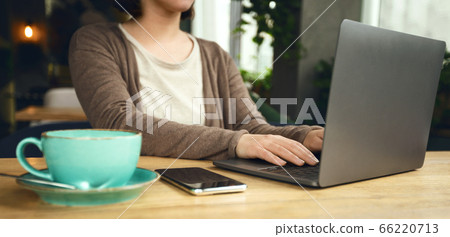 Unrecognizable Woman sitting in internet cafe with laptop Unrecognizable Woman sitting in internet cafe with laptop 66220713