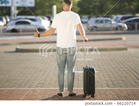 Tourist trying to catch taxi, arriving at airport Tourist trying to catch taxi, arriving at airport 66220714