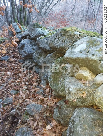 A stone wall built with natural stones blocks wild animals, wind and rain. 66221024