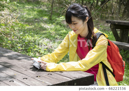 A woman sitting and looking at a picture of a digital camera 66221536