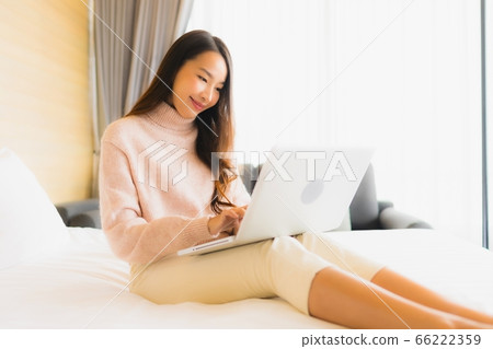 asian woman relax around outdoor swimming pool in hotel resort with palm tree at sunset or sunrise asian woman relax around outdoor swimming pool in hotel resort with palm tree at sunset or sunrise 66222359
