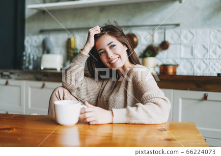 Young beautiful asian woman in cozy sweater on kitchen 66224073