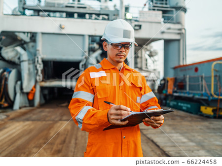 Filipino deck Officer on deck of offshore vessel or ship fills checklist. Paperwork at sea 66224458