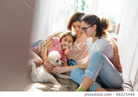 Happy family mother two daughters girls and poodle at home 66225448