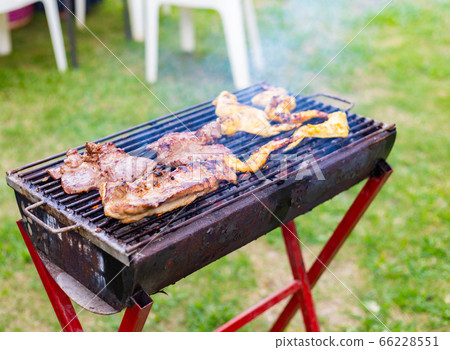 Cooking BBQ meat at festival outdoor in park. Cooking BBQ meat at festival outdoor in park. 66228551