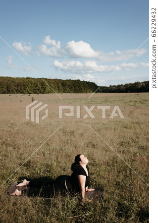 Overweight woman doing yoga exercise outdoor 66229432