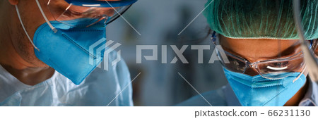 Surgeon and anastasiologist in uniform look down Surgeon and anastasiologist in uniform look down 66231130