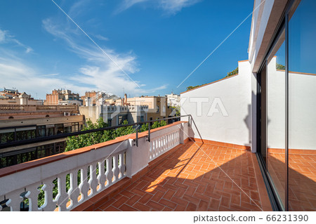 Empty sunny terrace, balcony of refurbished apartment with a view to the street and blue sky in the center of Barcelona Empty sunny terrace, balcony of refurbished apartment with a view to the street and blue sky in the center of Barcelona 66231390