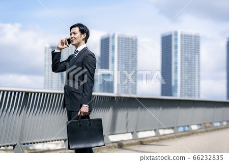 Businessman making a phone call _ Sky _ Building Businessman making a phone call _ Sky _ Building 66232835