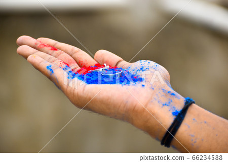 Close up of ring jewelry on human hand with vibrant holi multi colors powder. Close up of ring jewelry on human hand with vibrant holi multi colors powder. 66234588