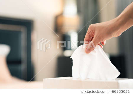 women hand picking napkin/tissue paper from the tissue box 66235031