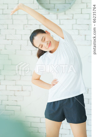A beautiful woman doing exercise at home 66235764
