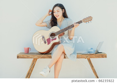A beautiful woman playing guitar A beautiful woman playing guitar 66235922