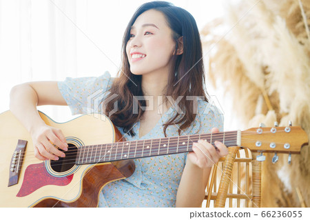 Beautiful woman playing guitar at home 66236055