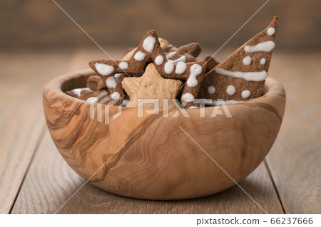 Gingerbread chrismas cookies in olive bowl on oak wood background with copy space 66237666
