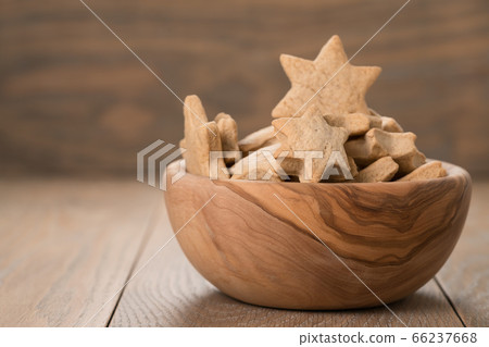 Gingerbread chrismas cookies in olive bowl on oak wood background with copy space 66237668