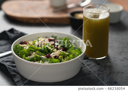 Salad with kale, cranberries and almond flakes in white bowl on linen napkin with copy space 66238054