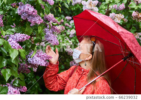 woman in a surgical protective mask tries to smell woman in a surgical protective mask tries to smell 66239032