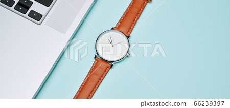 Wristwatch, laptop on empty blue background, top view Wristwatch, laptop on empty blue background, top view 66239397