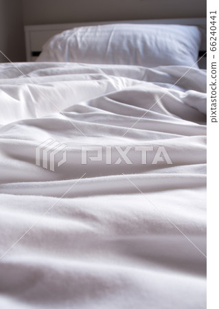 White blanket crumpled on the bed 66240441
