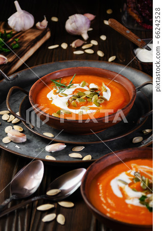 Clay dish with homemade rustic pumpkin soup with Clay dish with homemade rustic pumpkin soup with 66242528