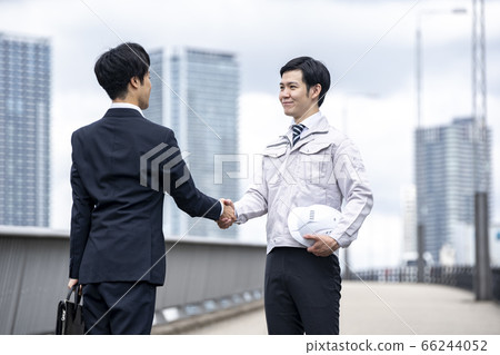 Businessman shaking hands with a worker Businessman shaking hands with a worker 66244052