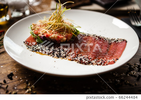 Tuna sashimi on white plate. Delicious healthy Japan traditional snacks seafood closeup served on a table for lunch in modern gourmet restaurant. 66244484