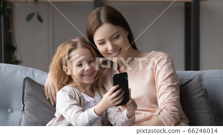 Happy young mom and little daughter use smartphone together 66246014