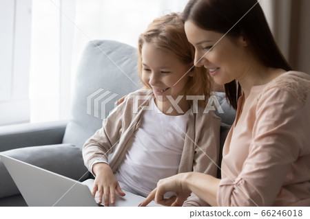 Smiling mother and small daughter using laptop together 66246018